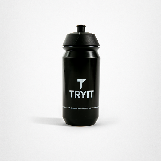 Schwarze Trinkflasche mit weißem "TRYIT"-Logo und Text "DIE FLASCHE AUS 100 % BIOLOGISCH ABBAUBAREM MATERIAL".