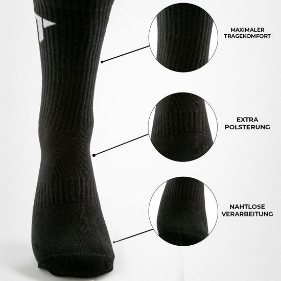 Nahaufnahme einer schwarze Sportsocke gepolstert mit Beschriftungen: "MAXIMALER TRAGEKOMFORT", "EXTRA POLSTERUNG", "NAHTLOSE VERARBEITUNG" und den entsprechenden Detail-Ausschnitte