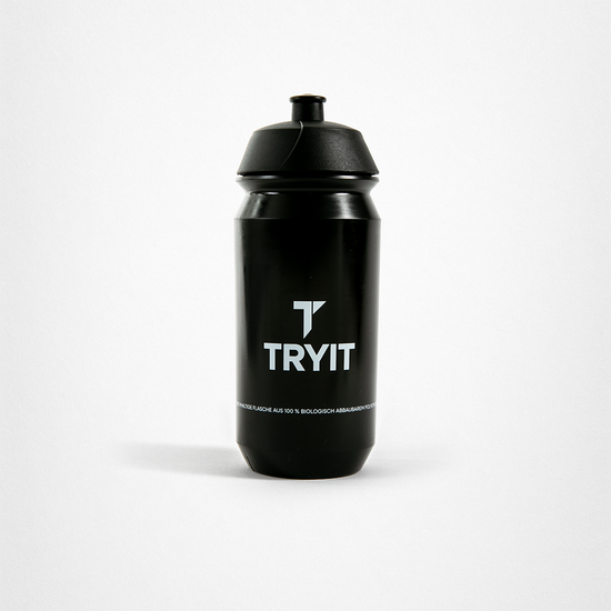 Schwarze Trinkflasche mit weißem "TRYIT"-Logo und Text "DIE FLASCHE AUS 100 % BIOLOGISCH ABBAUBAREM MATERIAL".