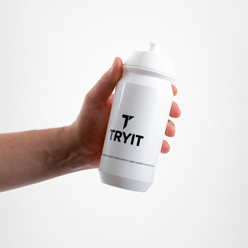 Eine Hand hält eine weiße TRYIT Trinkflasche mit schwarzem TRYIT Logo.